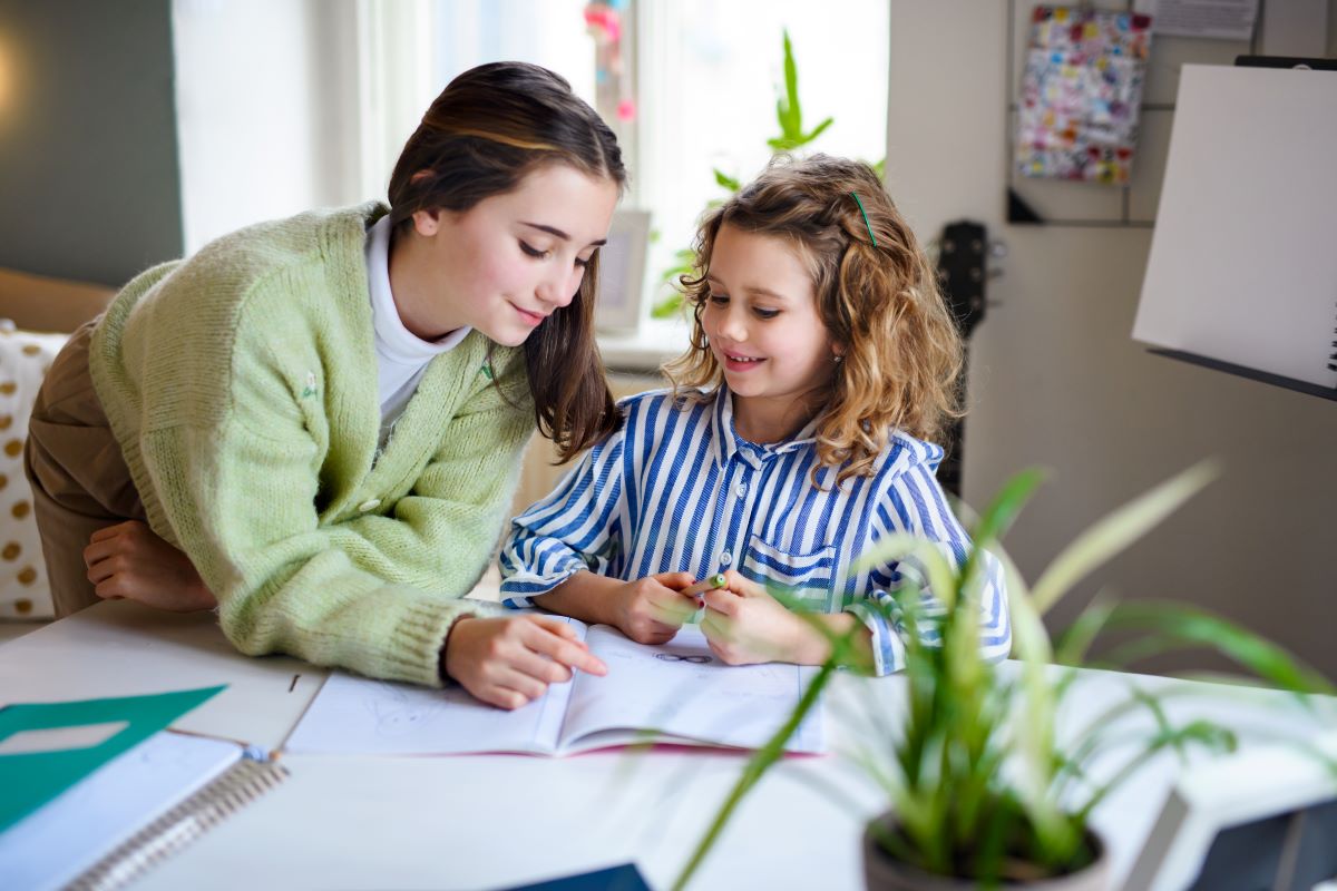teenager-girl-helping-sister-to-learn-indoors-at-h-2022-01-19-00-02-05-utc rodzina w czasie wolnym