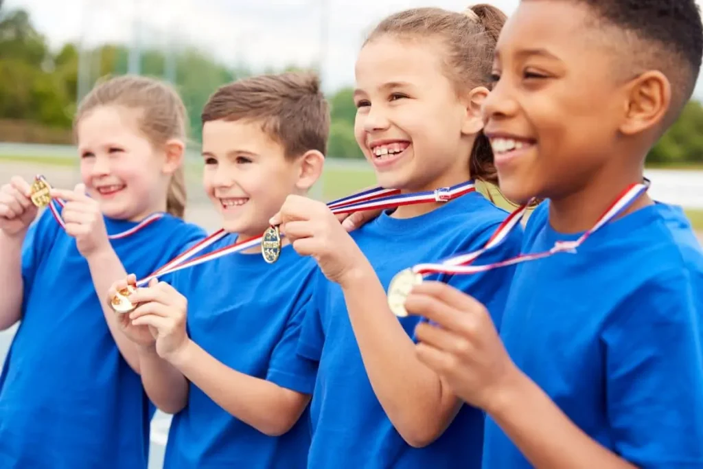 uśmiechnięte dzieci z medalami