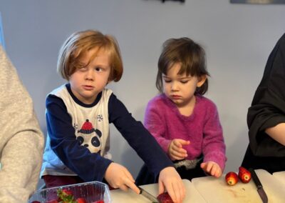 Dzieci kroją truskawki podczas warsztatów kulinarnych