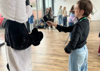 Uczennica przeprowadza wywiad z maskotką pandy